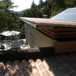 La toiture est terminée. Vue depuis le toit des chambres. Ce toit est plat et plus bas pour, à l'intérieur, réduire le volume d'air à chauffer ou à refroidir. La pente ouest du toit inversé (second plan) accueille 50m² de panneaux solaires (6kw/an).